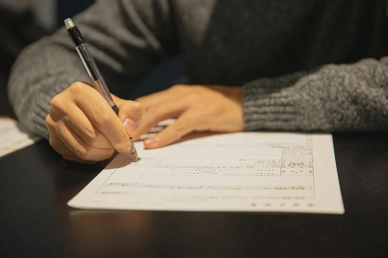 Main remplissant au stylo un formulaire de demande de droit d'accès avant envoi en lettre recommandée