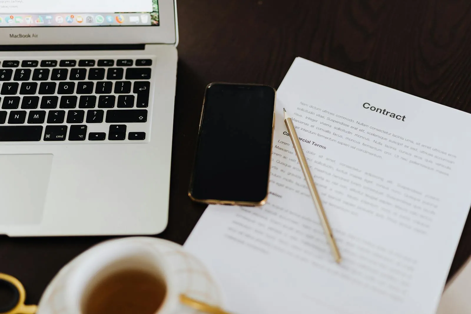 Ordinateur portable ouvert avec smartphone document et tasse de thé sur un bureau de travail